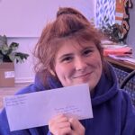 SJRC student Elizabeth holding an envelope with her voters registration