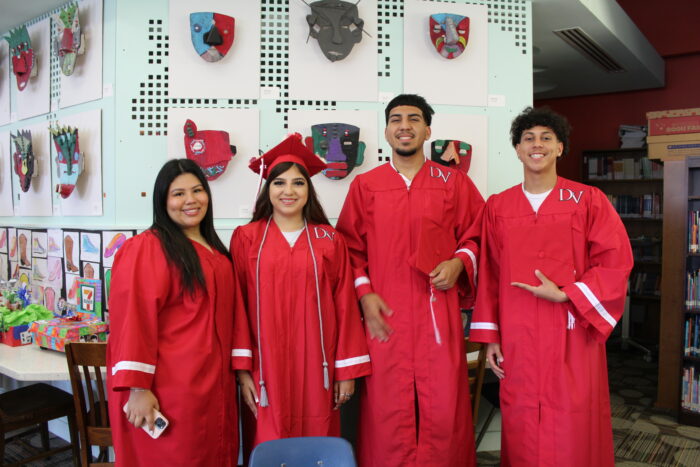 Four high school graduates in Del Valle graduation gowns