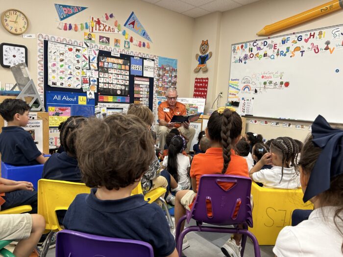 Pre-K students listen to Mr. Ronnie read a book