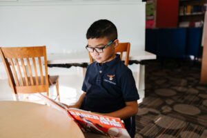 student reading a book about baseball in the library
