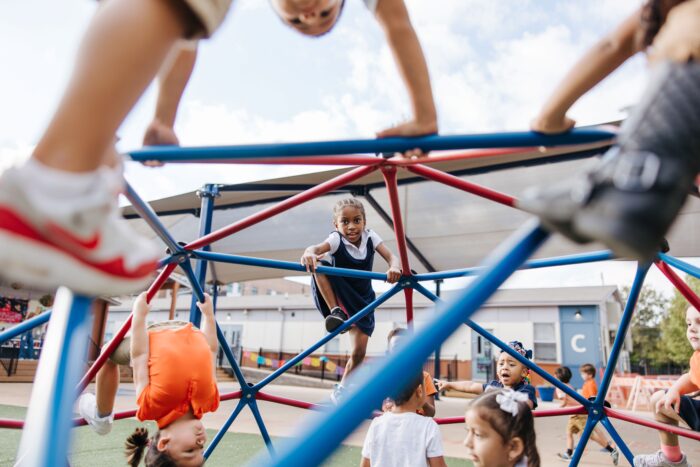 Student climbing the monkey bars on the playground