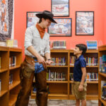 Clayton Bouwhuis and his mentee choose a book to read together.